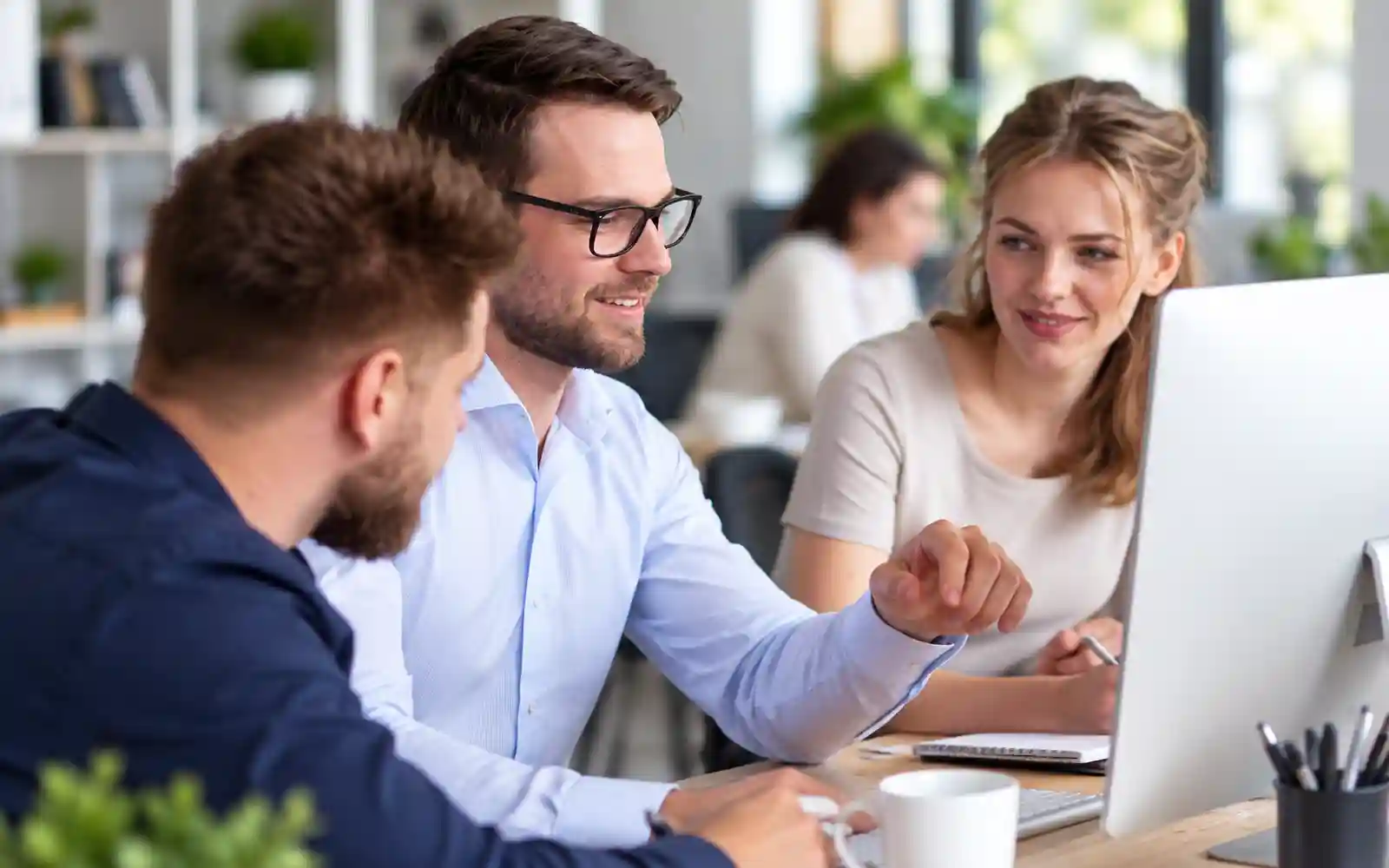 Professionnels échangeant autour d’un ordinateur lors d’un projet digital